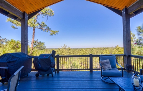 Spacious outdoor deck with wooded views and serene atmosphere, perfect for relaxation. For sale in Show Low, Arizona.
