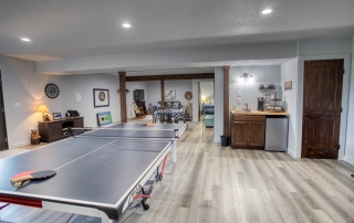 Spacious recreational room with laminate flooring, built-in storage, warm lighting. For sale in Show Low, Arizona.
