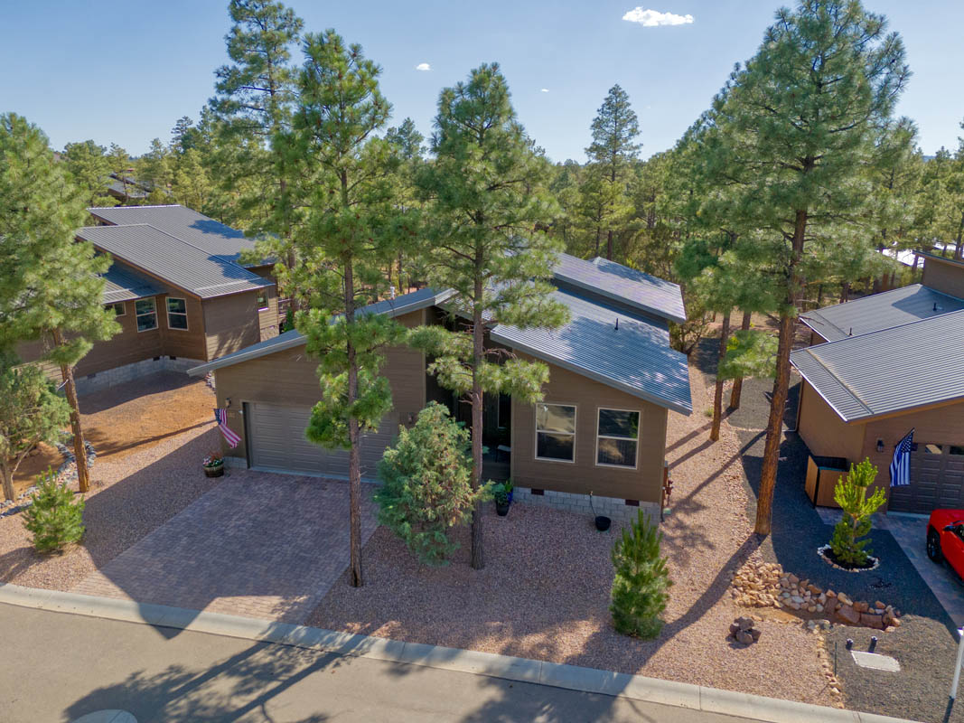 Exterior view of modern homes in a tree-filled neighborhood for sale in Show Low, Arizona. Peaceful and secluded setting.