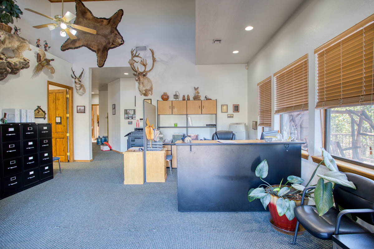 Showlow Office Buildings for Sale (1) Office space with carpet flooring, ample storage, wooden blinds, and a cozy, rustic ambiance for sale in Show Low, Arizona.