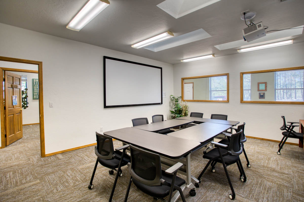 Showlow Office Buildings for Sale (11) Conference room with carpet flooring, white walls, natural light, and minimalistic storage. For sale in Show Low, Arizona.